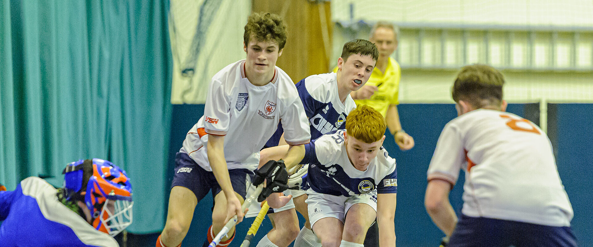 Two players challenging for the ball during an indoor hockey match