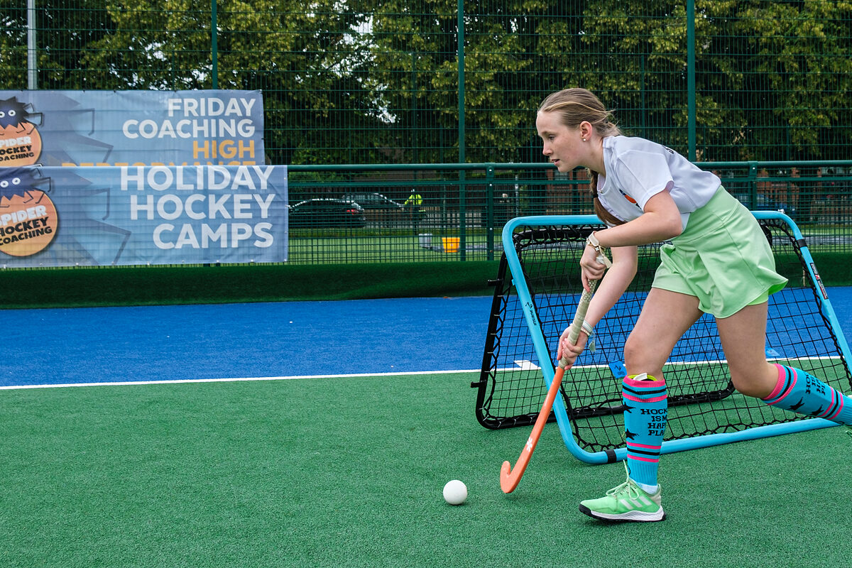 Players training beside a Spider Hockey Coaching holiday camps banner